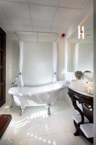 a white bathroom with a tub and two sinks at Casa Palacete 1822 in Granada +35 photos
