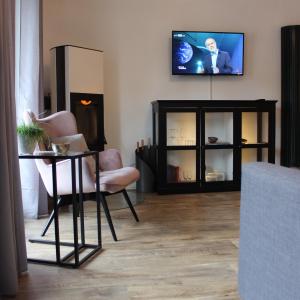 salon z telewizorem, stołem i krzesłami w obiekcie Wohnen am Solbad w mieście Bad Salzungen