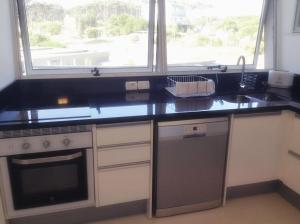 a kitchen with a counter and a sink and a window at Depto 203 Edificio Bikini Beach, Manantiales in Punta del Este