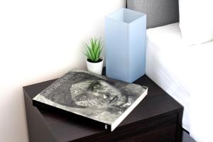 a book on a table with a vase on it at 168 - ExcellentStays - 2 Bedroom Flat in Stanwell
