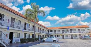 ein Auto, das auf einem Parkplatz vor einem Hotel parkt in der Unterkunft Hawthorne Plaza Inn Near LAX in Hawthorne