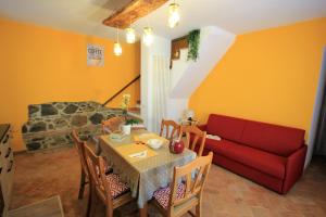 a living room with a table and a red couch at L’ANGOLETTO in San Lorenzo Nuovo