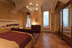 a bedroom with a large bed and a chandelier at Antico Hospitale in Dogliani