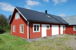 烏拉勒德的住宿－Flähult Ullared，红谷仓,设有白色门和黑色屋顶