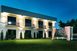 un gran edificio blanco con césped delante en CASA BUDISTEANU 2, en Focşani
