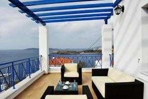 a balcony with two chairs and a table and the ocean at Beba's Villas in Batsi