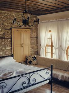 1 dormitorio con 1 cama y 1 sofá en Stone rooms 1850, en Gjirokastra