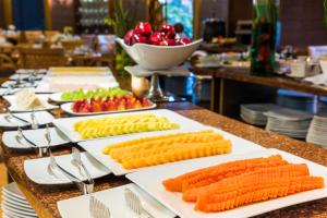 a table topped with white plates with carrots and vegetables at Cosmos 100 Hotel & Centro de Convenciones - Hoteles Cosmos in Bogotá +64 photos