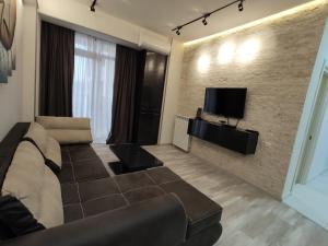 a living room with a couch and a flat screen tv at Tbilisi App 3 in Tbilisi City