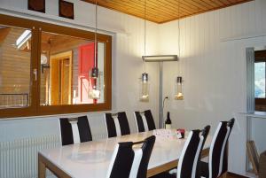 a dining room with a white table and black chairs at Aletschblick in Grächen