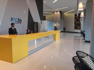 a man standing at a counter in a lobby at Flat Beach Barra - Praia do Paiva - Ilha do amor in Recife +19 photos
