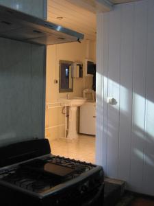 a stove top in a kitchen with a sink at Cosy home for short stay or a weekend getaway in Paramaribo