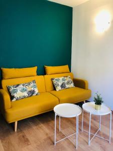 - un salon avec un canapé jaune et 2 tables dans l'établissement #T3 intra-muros Avignon, à Avignon