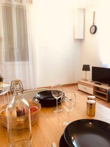 - une table à manger avec des verres à vin et une télévision dans l'établissement #T3 intra-muros Avignon, à Avignon
