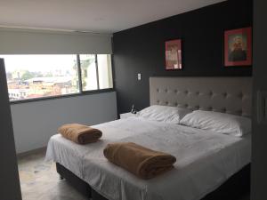 a bedroom with a large bed with two pillows on it at Hotel Garden City Boutique in Fusagasuga