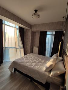 a bedroom with a bed with pillows and a window at Tbilisi App 2 in Tbilisi City +16 photos
