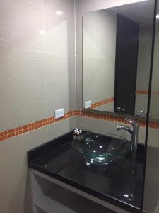 y baño con lavabo de cristal y espejo. en Hotel Garden City Boutique en Fusagasuga