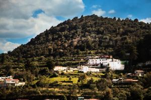 un pueblo en una colina con una montaña en Hotel Santiurde SOLO ADULTOS, en Mineral del Monte