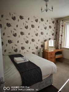 1 dormitorio con 1 cama y papel pintado con motivos florales en RICHFLO Holiday Rentals, en Mánchester