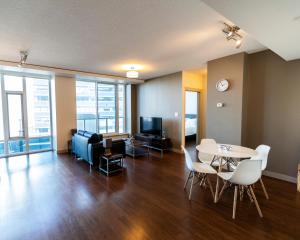 een woonkamer met een tafel en stoelen en een televisie bij Mayfair by Corporate Stays in Edmonton