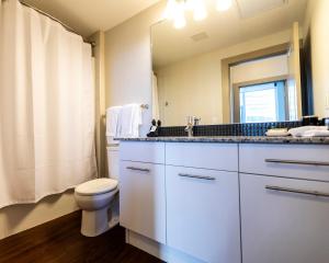 y baño con aseo, lavabo y espejo. en Mayfair by Corporate Stays en Edmonton