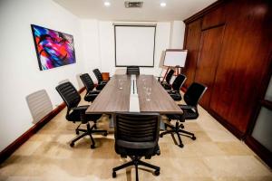 a conference room with a large wooden table and chairs at Hotel Dann Carlton Cali in Cali