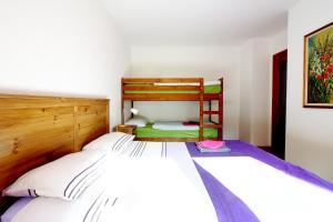 a bedroom with two beds and a bunk bed at Nonostantetutto B&B in Pieve di Cadore