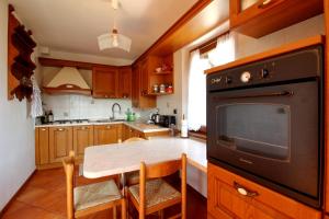 a kitchen with a table and a black oven at Nonostantetutto B&B in Pieve di Cadore