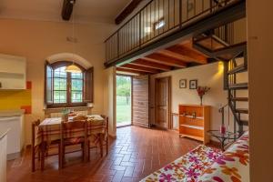 una cucina e una sala da pranzo con tavolo e scala di Casa Gabry a Sarteano
