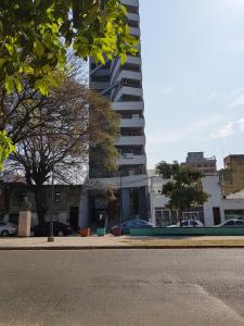una calle de la ciudad con un edificio alto en el fondo en Boulevard Lavalle Apartament en San Miguel de Tucumán