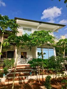 una casa bianca con degli alberi di fronte di Casa Mediterranea a Santa Marta