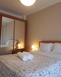 a bedroom with two beds and two lamps and a mirror at Guesthouse Metro Station in Matosinhos