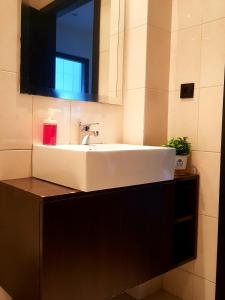 W łazience znajduje się biała umywalka i lustro. w obiekcie Guesthouse Metro Station w mieście Matosinhos