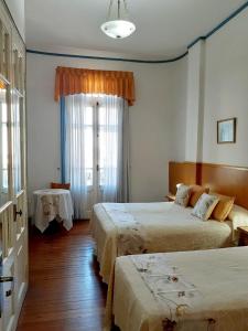 a hotel room with two beds and a window at Hotel Benevento in La Plata