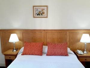 1 dormitorio con 1 cama blanca y 2 lámparas en Hotel Benevento en La Plata