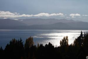 Blick auf einen großen Wasserkörper mit Bergen in der Unterkunft Pajaro Azul in San Carlos de Bariloche