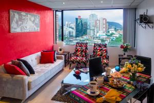 sala de estar con sofá y pared roja en Executive Suite, en Quito