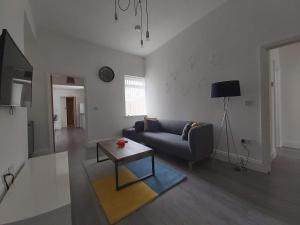 een woonkamer met een bank en een tafel bij Dwell Living - No 61 in Sunderland