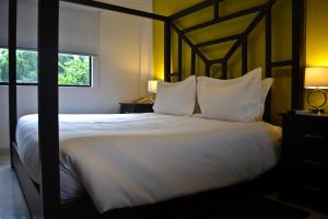 a bedroom with a large bed with white sheets and pillows at Wayak Hotel in Managua