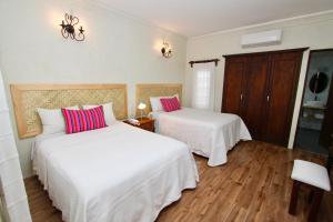 um quarto com 2 camas com lençóis brancos e almofadas cor-de-rosa em Hotel Trébol em Oaxaca de Juárez