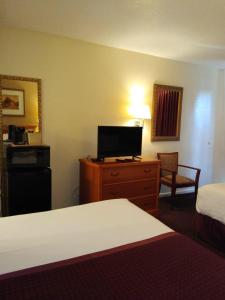 a hotel room with a bedroom with a bed and a television at Knights Inn San Antonio near Frost Bank Center in San Antonio