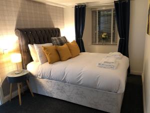 a bedroom with a bed with yellow pillows and a window at The Nook - Coorie Doon in Ayr