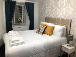 a bedroom with a large white bed with blue curtains at The Nook - Coorie Doon in Ayr