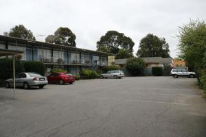 a parking lot with cars parked in front of a building at The Sands Motel Adelaide in Adelaide