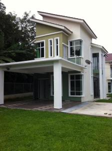 a white and green house with a green lawn at NeoHomeStay Gapam Lestari in Malacca