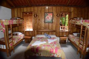 a room with three bunk beds and a room with a bed at Recreo Verde Hot Springs & Spa in Marsella