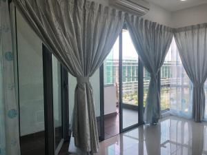 a room with large windows with curtains and a view at The Loft Imago in Kota Kinabalu