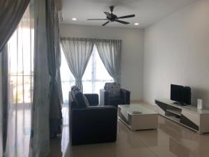 a living room with two chairs and a ceiling fan at The Loft Imago in Kota Kinabalu