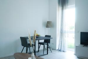- un salon avec une table, des chaises et une télévision dans l'établissement Prime Park Deluxe Apartment Aschaffenburg, à Aschaffenbourg