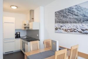 eine Küche und ein Esszimmer mit einem Tisch und Stühlen in der Unterkunft Sunshine Appartements Schilchegger in Obertauern